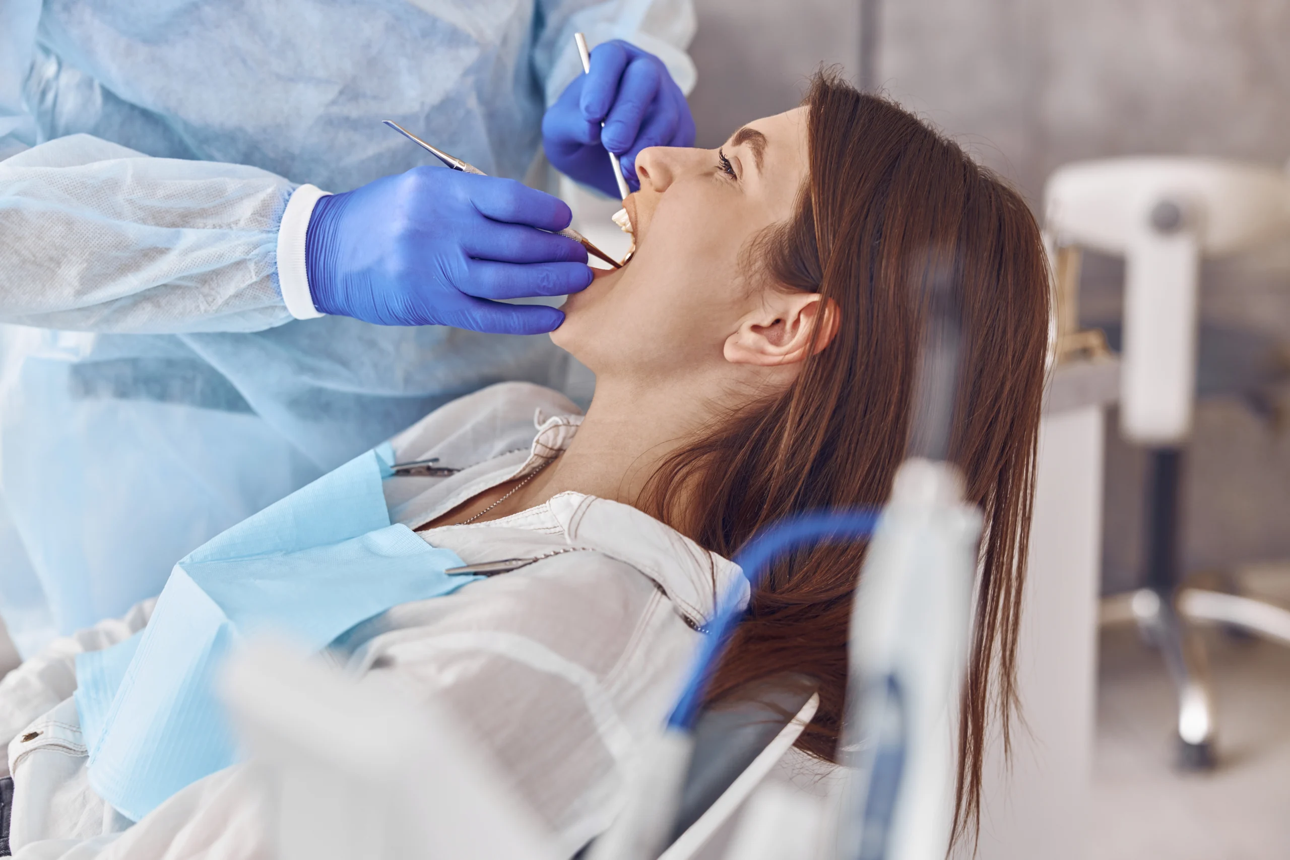 Everything You Need to Know About Jaw Pain: Causes, Symptoms, Treatment & Prevention 1 professional doctor is doing tooth surgery happy caucasian woman modern dental cabinet scaled