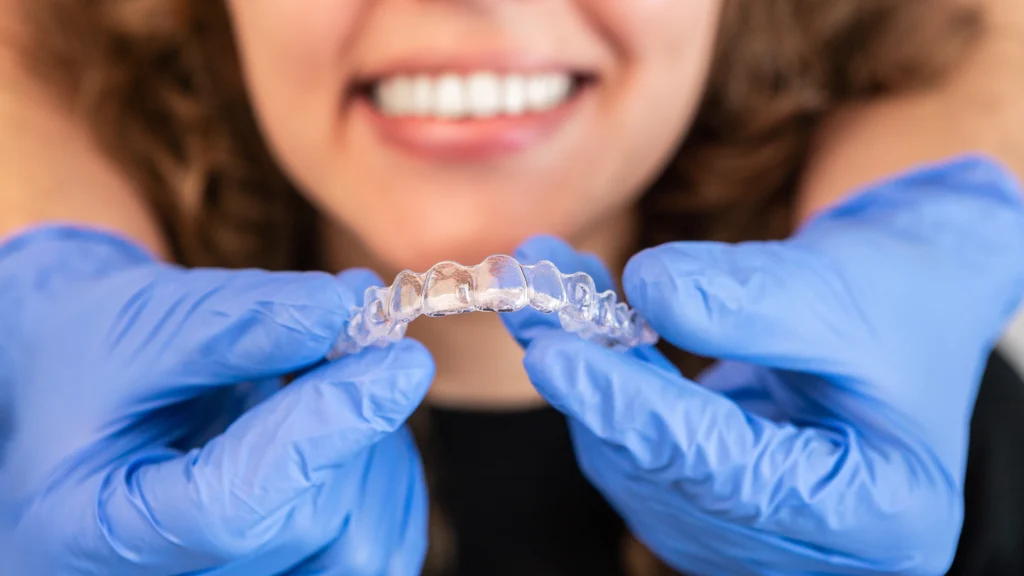 orthodontist-doctor-putting-silicone-invisible-transparent-braces-woman-teeth-scaled