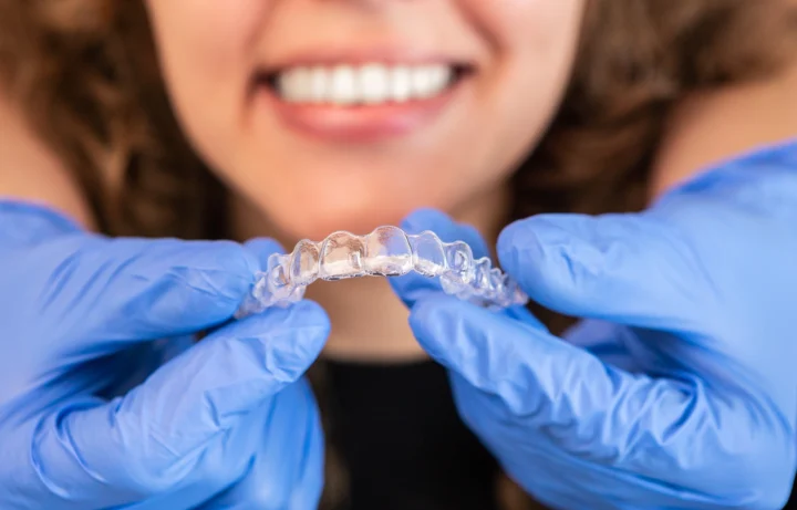 orthodontist-doctor-putting-silicone-invisible-transparent-braces-woman-teeth-scaled
